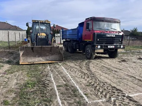 Traktorbager CAT a sklápače Tatra 815 pri príprave pozemku