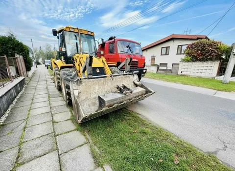 Traktorbager JCB a Tatra 815 pri práci v obci